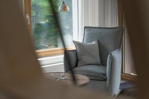 een stoel met een tafel voor een raam bij Ferienwohnungen Alpentraum - Landhaus Gutermann in Oberstdorf