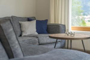 ein Wohnzimmer mit einem Sofa und einem Tisch in der Unterkunft Ferienwohnungen Alpentraum - Landhaus Gutermann in Oberstdorf