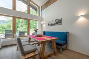 uma sala de jantar com uma mesa de madeira e cadeiras azuis em Ferienwohnungen Alpentraum - Landhaus Gutermann em Oberstdorf