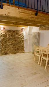 Zimmer mit einem Tisch, Stühlen und einer Steinmauer in der Unterkunft Noi Due in Gaeta