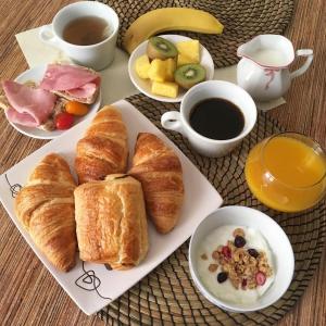 una mesa con un plato de cruasanes y una taza de café en Lou Mistral en Moustiers-Sainte-Marie