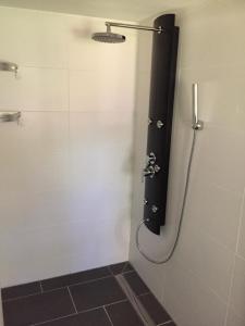 a shower in a bathroom with a black shower curtain at Waldhaus Halvor in Zichtau