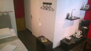 a small hotel room with a bed and a table at Chambres D'Hotes "Les Chiens Verts", jardin, terrasse, parking privé in Hauteville-Lompnes