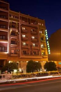 un grand bâtiment la nuit avec une rue devant lui dans l'établissement Hotel Amalay, à Marrakech