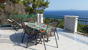 a table and chairs on a balcony with the ocean at Apartments Vila Vino in Sveta Nedelja
