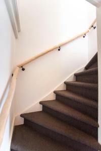 a staircase in a house with brown carpet at Bamboa Beachhouse in Zandvoort
