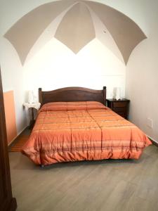 a bedroom with a large bed with an orange blanket at Casette sul Porto in Ischia