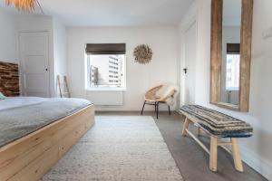 - une chambre avec un lit, une chaise et des fenêtres dans l'établissement Bamboa Beachhouse, à Zandvoort