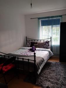 Comfortable Host, in zone 2-3 في لندن: غرفة نوم مع سرير مع قبعة أرجوانية عليه