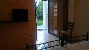 a bedroom with a bed and a door with a television at Agriturismo Francadu in Santu Lussurgiu