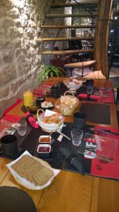 a wooden table with food on top of it at Chambres D'Hotes "Les Chiens Verts", jardin, terrasse, parking privé in Hauteville-Lompnes