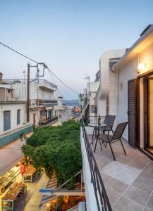 a balcony with a table and chairs on a building at The Junction Appartment in Agia Galini
