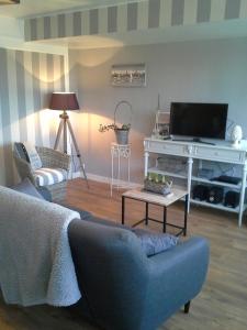 a living room with a couch and a tv and a table at Abri du Pêcheur in La Forêt-Fouesnant