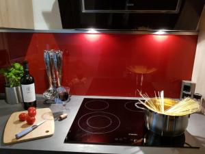 a stove top with a pot of pasta and a bottle of wine at Haus Ani Winterberg in Winterberg