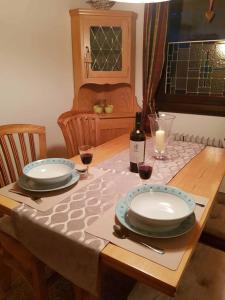 una mesa con dos platos y una botella de vino en Haus Ani Winterberg en Winterberg