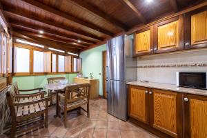 a kitchen with wooden cabinets and a table and a refrigerator at First Line of The Beach La Garita in La Garita