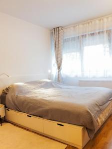 a bed in a white bedroom with a window at Apartman Delux Adda in Zagreb