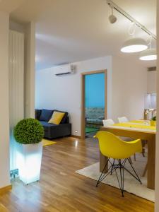 a living room with a table and a yellow chair at Apartman Delux Adda in Zagreb