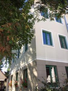 a white building with green windows at Ferienwohnungen Babo 6 in Regensburg