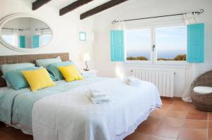 a bedroom with a bed with a mirror and a window at San Colomban in Sant Lluis