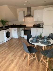 a kitchen with a table and chairs in a kitchen at Three Bedroom Townhouse with Parking in Telford