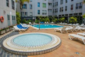 a swimming pool with lounge chairs and a hotel at APARTAMENT SARDINA NEAR THE BEACH WITH POOL AND WIFI e in Gáldar