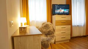a dog sitting at a desk in front of a tv at Jules Studio Downtown in Braşov