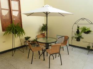 a table and chairs with an umbrella in a room at Hostal Antonio in Popayan