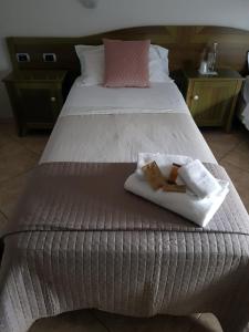 a large bed with two towels and two towels at Hotel Monte Sirai in Carbonia
