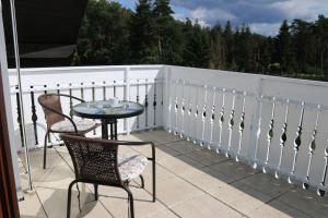 eine Terrasse mit einem Tisch und Stühlen auf dem Balkon in der Unterkunft Pension Ottenheide in Schloß Holte-Stukenbrock