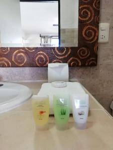 Baño con 3 botellas de jabón en una encimera en Hotel Green 16 en Cancún
