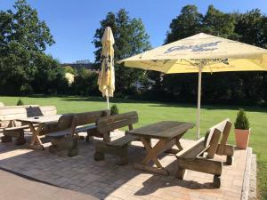 a picnic table and an umbrella and a table and benches at Gästehaus Sandra in Sulzbach-Rosenberg