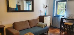 a living room with a couch and a mirror at Apartment Terra in Mali Lošinj