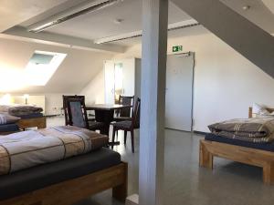 two beds in a room with a table and chairs at Gästehaus Sandra in Sulzbach-Rosenberg