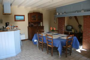 een eetkamer met een blauwe tafel en stoelen bij Les deux caps in Carneville