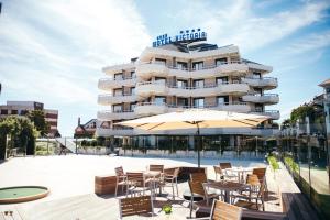 a hotel with a patio with chairs and an umbrella at Gran Hotel Victoria in Santander