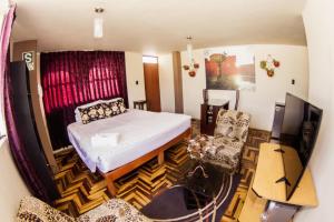 アレキパにあるSillary Hostal Boutiqueのベッド、机、テレビのある寝室