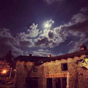 un cielo a la luz de la luna sobre un edificio de piedra con una casa en La Casa Ponca, en Cormòns