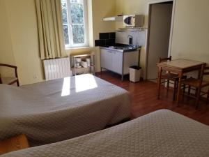 una camera d'albergo con due letti e una cucina di Chateau de Faudade a Lévignac-sur-Save