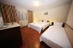 a hotel room with two beds and a desk at Pensiunea Criveanu in Horezu