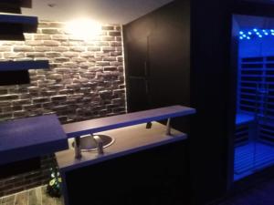ein Badezimmer mit einer blauen Theke und einer Ziegelwand in der Unterkunft magnifique loft avec jacuzzi et sauna privatif in Ferrière-la-Grande