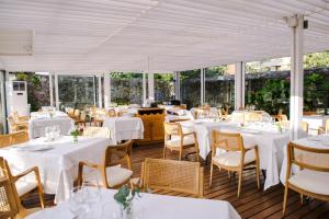 a restaurant with white tables and chairs and windows at Gran Hotel Victoria in Santander