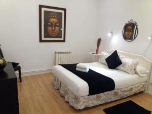 1 dormitorio con 1 cama con edredón blanco y negro en Casa de Huéspedes Prada, en Madrid