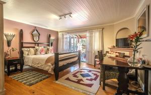 a bedroom with a bed and a desk and a television at Inn-Style in Cape Town