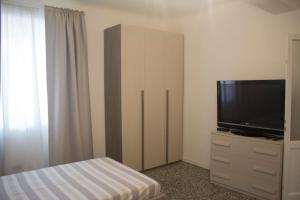 a bedroom with a tv and a dresser with a bed at Rho-Fiera - Appartamento in antica cascina in Pero