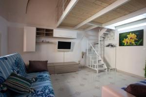 a living room with a blue couch and a tv at 4sisters' Open Space in Aradeo