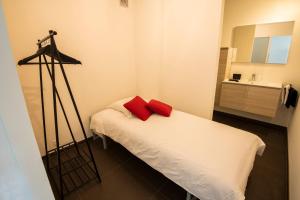 a small room with a bed with red pillows on it at Into the Sea in Middelkerke