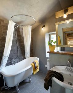 een badkamer met een bad en een wastafel bij Moulin des Borderies in Singles