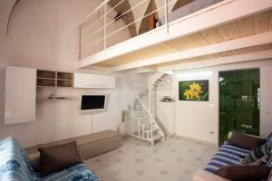 a living room with a couch and a stair case at 4sisters' Open Space in Aradeo