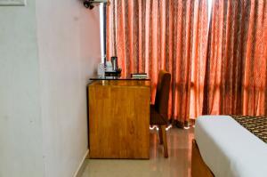 a bedroom with a desk and a bed and a chair at OPALO Kailas Kovalam in Kovalam